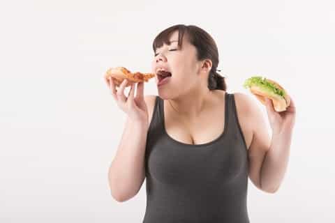 ピザやハンバーガーを食べる女性